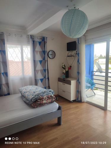 a bedroom with a bed and a sliding glass door at Villa Saphira in Antananarivo