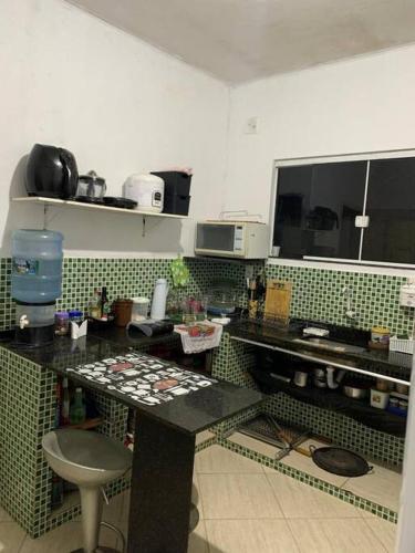 a kitchen with green and white tiled walls at Aluguel por temporada Unamar in Tamoios