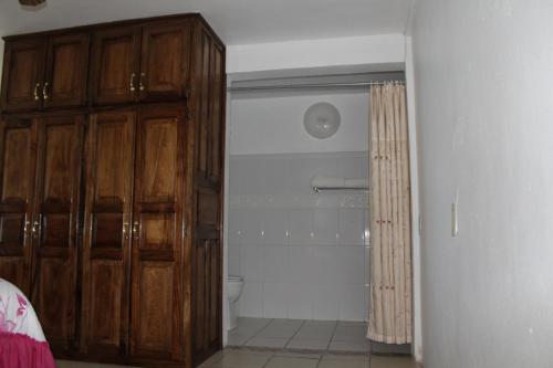 a bathroom with a toilet and a wooden cabinet at Freedom Shores "La Gringa" Hotel - Universally Designed in Isla Aguada