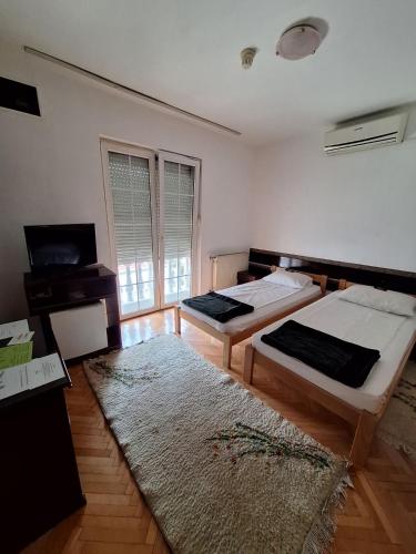 a room with two beds and a television in it at Vila Grinka M in Zaječar