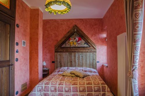 a bedroom with a large bed with orange walls at La Maison Du Bon Megnadzo in Doues