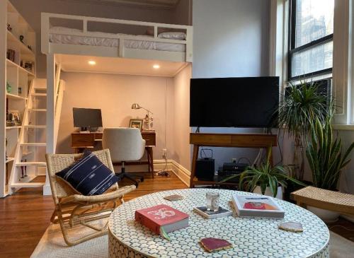 a living room with a loft bed and a table at Charming Studio West Village in New York