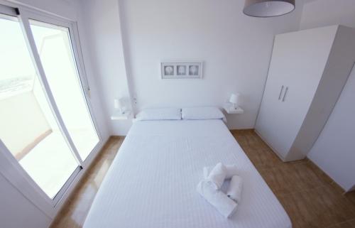 Cette chambre blanche dispose d'un lit et d'une grande fenêtre. dans l'établissement Be Free Laguna Playa, à Roquetas de Mar