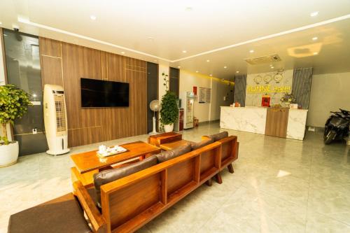 vestíbulo con sofá, mesa y TV en Sonne Hotel Quang Binh en Ðộng Hỏi