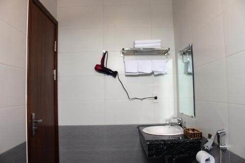 a bathroom with a sink and a phone on the wall at Sonne Hotel Quang Binh in Ðộng Hỏi