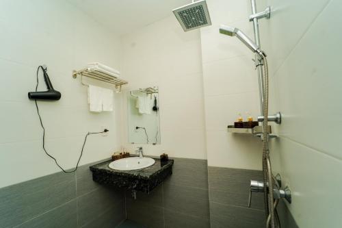 a bathroom with a sink and a shower at Sonne Hotel Quang Binh in Ðộng Hỏi