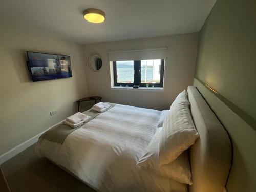 a bedroom with a large white bed with a window at Flat in Gourock - The Wedge in Gourock