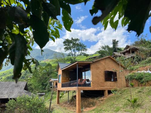 une maison sur une colline avec un balcon dans l'établissement Hmong house Sapa, à Sa Pa