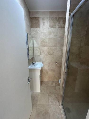 een kleine badkamer met een wastafel en een douche bij Modern flat in Victoria in Londen