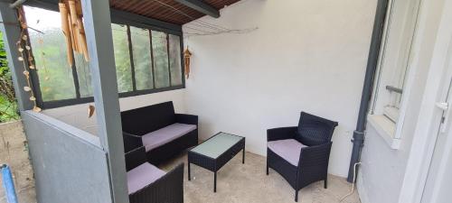 einen Balkon mit 2 Stühlen und einem Tisch in der Unterkunft Maison proche Disney in Villenoy