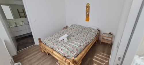 - une petite chambre avec un lit et une couverture fleurie dans l'établissement Maison proche Disney, à Villenoy