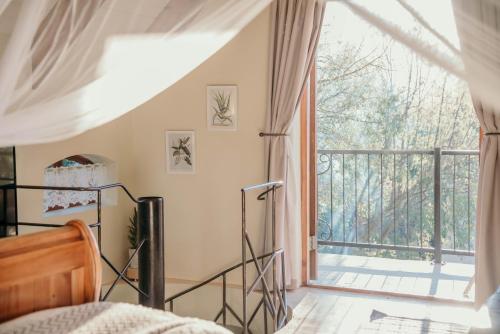 a bedroom with a bed and a balcony at Silky Oaks Couples Retreat in Riebeek-Kasteel