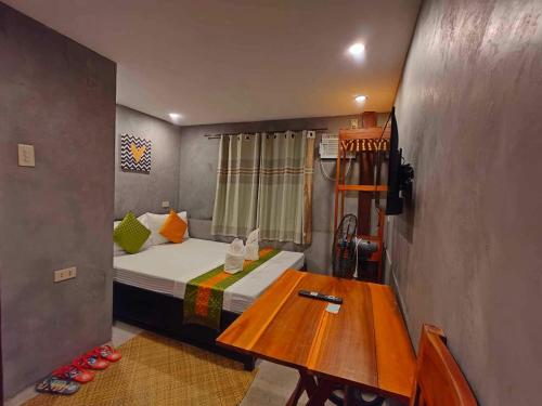 a small room with a bed and a wooden table at RL Harbor Inn in El Nido