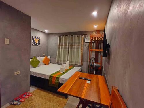 a small room with a bed and a wooden table at RL Harbor Inn in El Nido