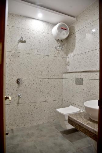 a bathroom with a toilet and a sink at HOTEL AROMA CROWN in Zirakpur