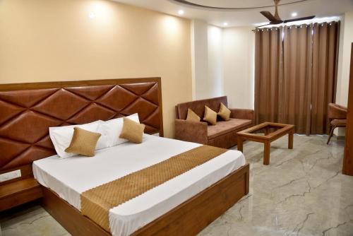 a hotel room with a bed and a chair at HOTEL AROMA CROWN in Zirakpur