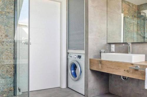 a bathroom with a washing machine and a sink at Golden Apartments Gdansk&SwB12 in Gdańsk