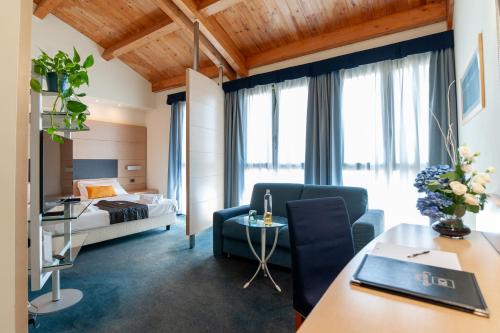 ein Hotelzimmer mit einem Bett und einem Wohnzimmer in der Unterkunft Concordia Hotel in San Possidonio