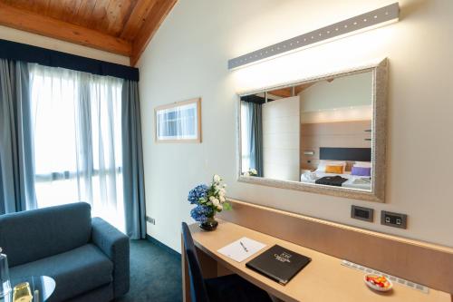 Zimmer mit einem Schreibtisch und einem Spiegel in der Unterkunft Concordia Hotel in San Possidonio