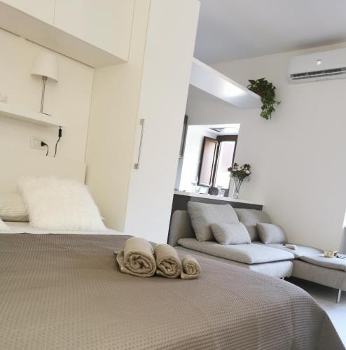 a white bedroom with a bed and a couch at Da Roxy in Casale Litta