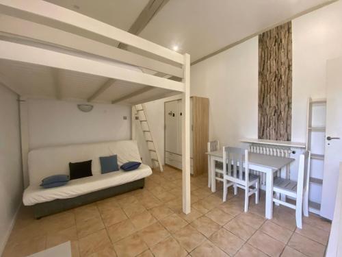 - une chambre avec des lits superposés, une table et un bureau dans l'établissement Studio avec jardin privatif au calme place de parking, à Hyères
