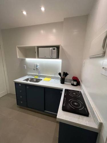 uma pequena cozinha com fogão e micro-ondas em Apartamento Nictheroy em Niterói