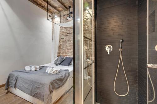 a bathroom with a shower and a bed in a room at Vigna Vecchia Studio by Mamo Florence in Florence