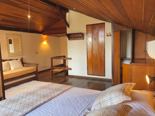 a bedroom with a bed and a wooden ceiling at Pousada Morro do Forte in Paraty
