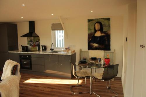 a kitchen with a table and a kitchen with a painting at White Swan Inn in Belford