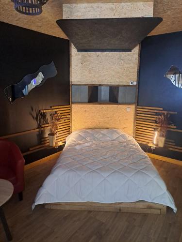 ein Schlafzimmer mit einem großen weißen Bett in einem Zimmer in der Unterkunft suite tylie avec baignoire balneo type SPA 