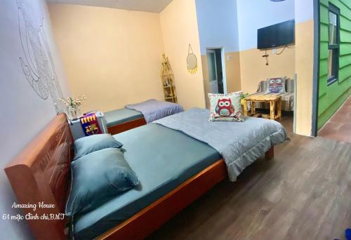 1 Schlafzimmer mit 2 Einzelbetten und einem TV in der Unterkunft Amazing House in Buôn Ðũng