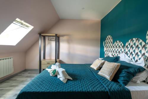 - une chambre avec un lit bleu et des oreillers dans l'établissement LA TOULOTTE chez Claire et Christian, à Sancy-lès-Provins