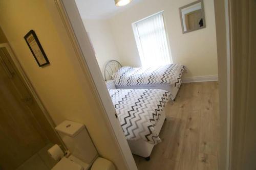a small bedroom with a bed and a window at Newly refurbished village flat in Cullybackey