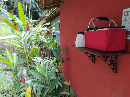 a red wall with a red bag hanging on a wall at Chalés Terras Altas de Paraty in Paraty