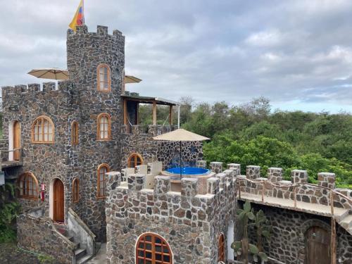 een stenen gebouw met een paraplu erop bij La Fortaleza De Haro in Puerto Ayora