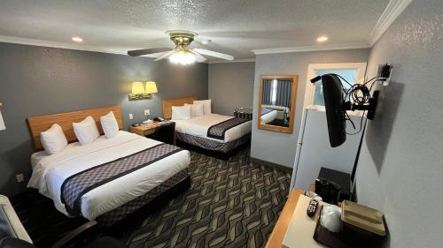 a hotel room with two beds and a desk at Purple Sage Motel in Snyder