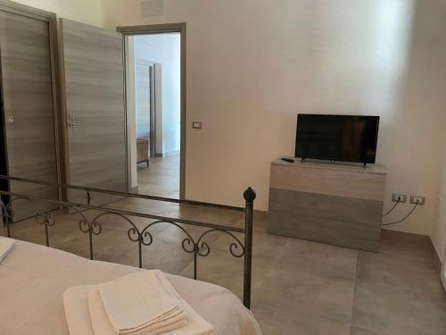 a bedroom with a bed and a flat screen tv at Home Paradise in Marsala