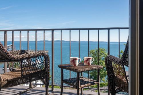 a balcony with two chairs and a table with two cups at Atlantic Oceanside Hotel & Conference Center in Bar Harbor