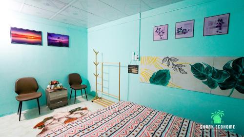 um quarto com uma cama e duas cadeiras em SHARK ECOHOME BẾN TRE em Ấp Phong Phú