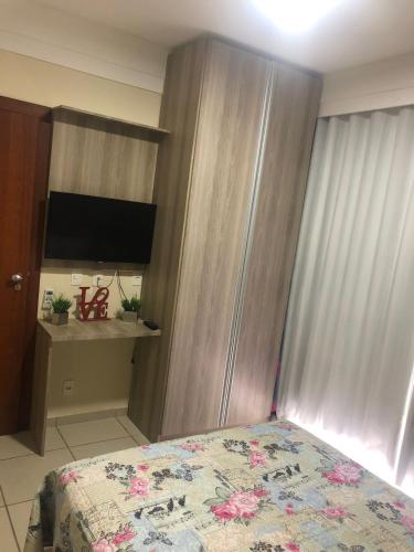 een slaapkamer met een bed en een tv in een kamer bij aldeia das aguas hotel in Além Paraíba