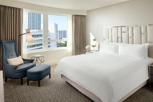 a hotel room with a bed and a chair and a window at Fontainebleau #1 Luxury Relax in Miami Beach