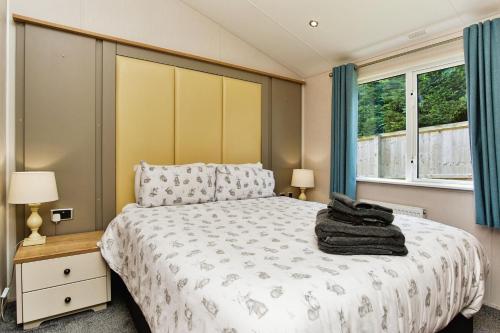 a bedroom with a bed and two windows at The Lodge in Ryde