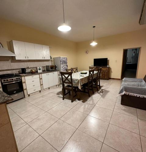 una cocina con mesa y sillas y una cocina con armarios blancos. en Dpto en el corazon de Mendoza en Mendoza