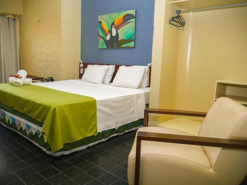 a hotel room with a bed and a chair at Marbello Ariau Hotel in Fortaleza