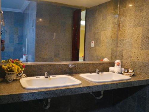 a bathroom with two sinks and a large mirror at Marbello Ariau Hotel in Fortaleza