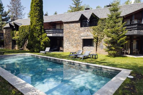uma piscina em frente a uma casa em Hotel Xalet del Golf em Puigcerdà