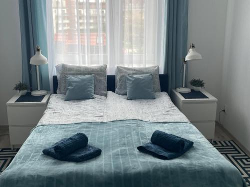 a large bed with blue pillows on top of it at Apartament Natalia in Hel