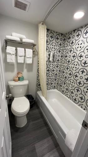 a bathroom with a toilet and a bath tub at Town Place Studio in Snyder