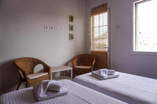 Cozy Apartment in La Laguna في لا لاغونا: غرفة بسريرين وكراسي ونافذة