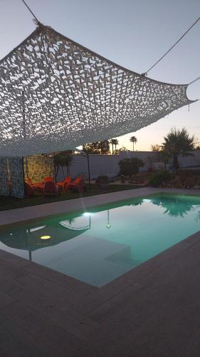 a swimming pool with a canopy over it with chairs at Casa Oliva 52 in Seville